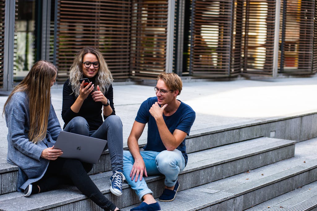 Three Persons Sitting on the Stairs Talking With Each Other | How to apply for Queen Elizabeth Commonwealth Scholarships